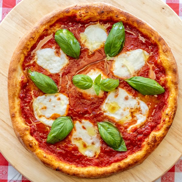A freshly baked Margherita pizza with rich red sauce, melted mozzarella, and fresh basil leaves.
